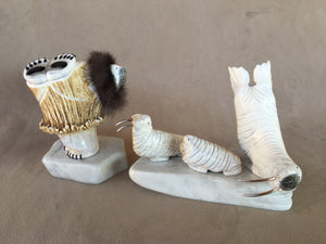 A six piece Elk antler set of a polar bear wearing a parka with a rabbit ruff. His eyes, claws and paws are inlaid pen shell. There are three walrus. A father and mother with sterling silver tusks and the third a calf with no tusks. Two white italian marble serve as icebergs. 