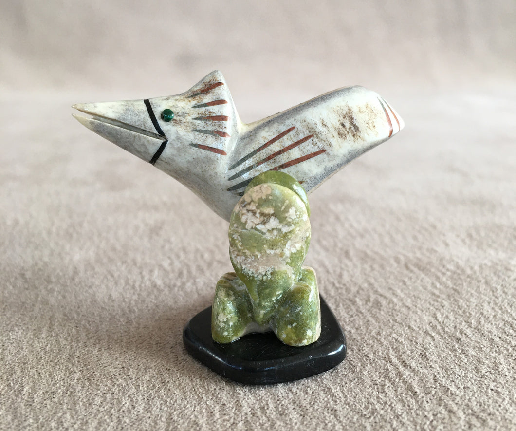 A road runner in its environment. Searching for food. He is carved of Elk antler inlaid with malachite eyes and has black jet, green serpentine and pipe stone pigment for detailing. The Cactus is carved of green serpentine. The legs of the road runner are copper round wire and the base is black marble. 